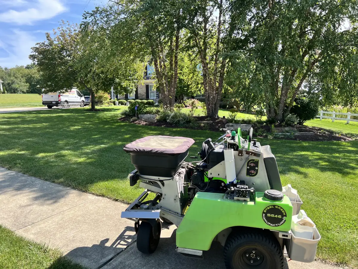 Professional spreader equipment applying fertilizer on a residential lawn